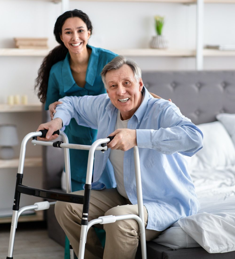 female-nurse-helping-elderly-male-with-walking-frame-stand-up-from-bed-at-home-professional-care.jpg female-nurse-helping-elderly-male-with-walking-frame-stand-up-from-bed-at-home-professional-care.jpg